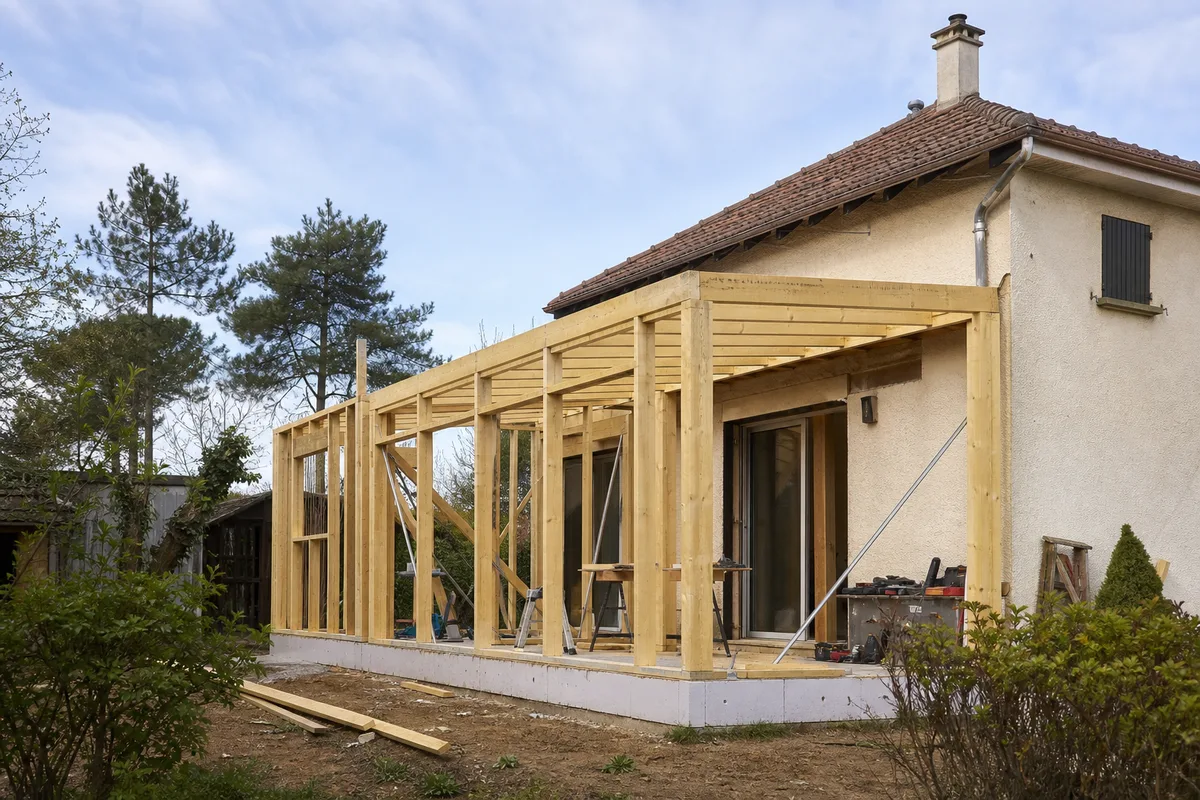Chantier d’extension à ossature bois en cours d’assemblage contre une maison